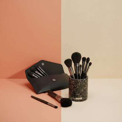 The Shazory 12-piece professional makeup brush set displayed in a stylish black terrazzo vanity holder with a matching black travel pouch, available at getshazory.com